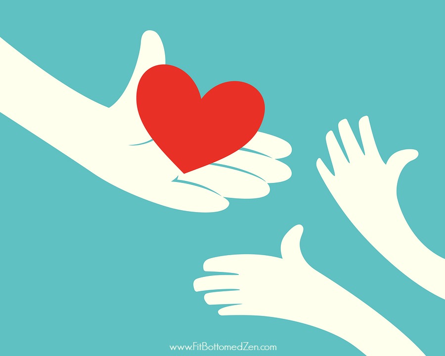 Close up of hand holding red heart and hands of children on green background